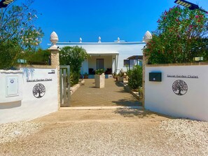 A gated entrance to a building with a sign reading 'Secret Garden Chalet.'