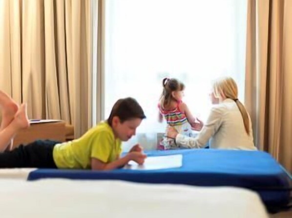Een hotelkamer met een bed, een raam met gordijnen en uitzicht op het omliggende landschap.