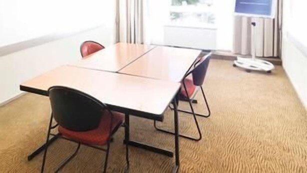 A conference room with a table, chairs, a whiteboard, and a poster. - Novotel Aix-en-provence Beaumanoir (Aix-en-Provence)
