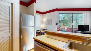 A kitchen with a refrigerator, sink, wooden countertop, and a window with a view of trees. - Comfortable, chic condo with mountain views - great Olympic Valley location (Squaw Valley)