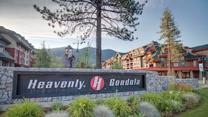 Un letrero de hotel con 'Heavenly H Gondola' y un muro de piedra con plantas.