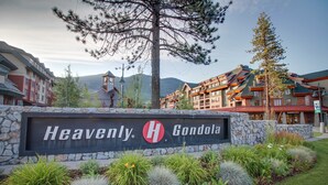 Une enseigne d’hôtel indiquant « Heavenly H Gondola » et un mur de pierre orné de plantes.