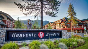 A hotel sign with 'Heavenly Gondola' written on it, surrounded by a landscaped garden with various plants and a stone wall. - Cozy townhouse with pool access, deck, fireplace, and WiFi (South Lake Tahoe)