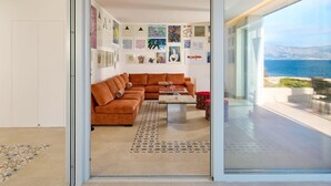 A modern living room with a sofa, coffee table, and artwork on the walls. - Beachfront Stay With Private Pool (Supetar)