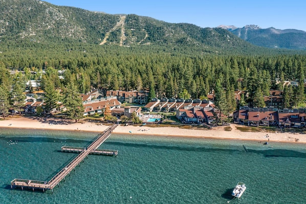 Une station balnéaire dotée d’une jetée, d’une plage et offrant une vue sur les montagnes.