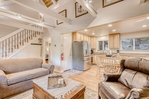A spacious living area with a staircase, a kitchen with wooden cabinets, and a dining area with a table and chairs. - Spacious lodge with wonderful views & large deck - great location, walk to trail (South Lake Tahoe)