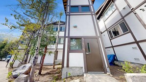 A modern building with a flat roof, large windows, and a door. - Centrally located condo with pool, tennis, hot tubs, & fireplace - near skiing (Squaw Valley)