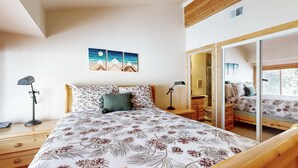 A bedroom with a bed, bedside tables, a mirror, and a painting on the wall. - Centrally located condo with pool, tennis, hot tubs, & fireplace - near skiing (Squaw Valley)