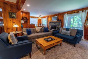A cozy living room with two sofas, a coffee table, and a fireplace. - Welcoming home near the lake with furnished deck & large, enclosed yard (Tahoe Vista)