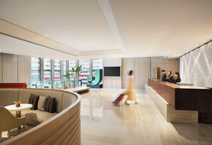 A modern hotel lobby with a reception desk, seating area, and large windows. - Hotel Jen Hong Kong by Shangri-la (Hong Kong Island)