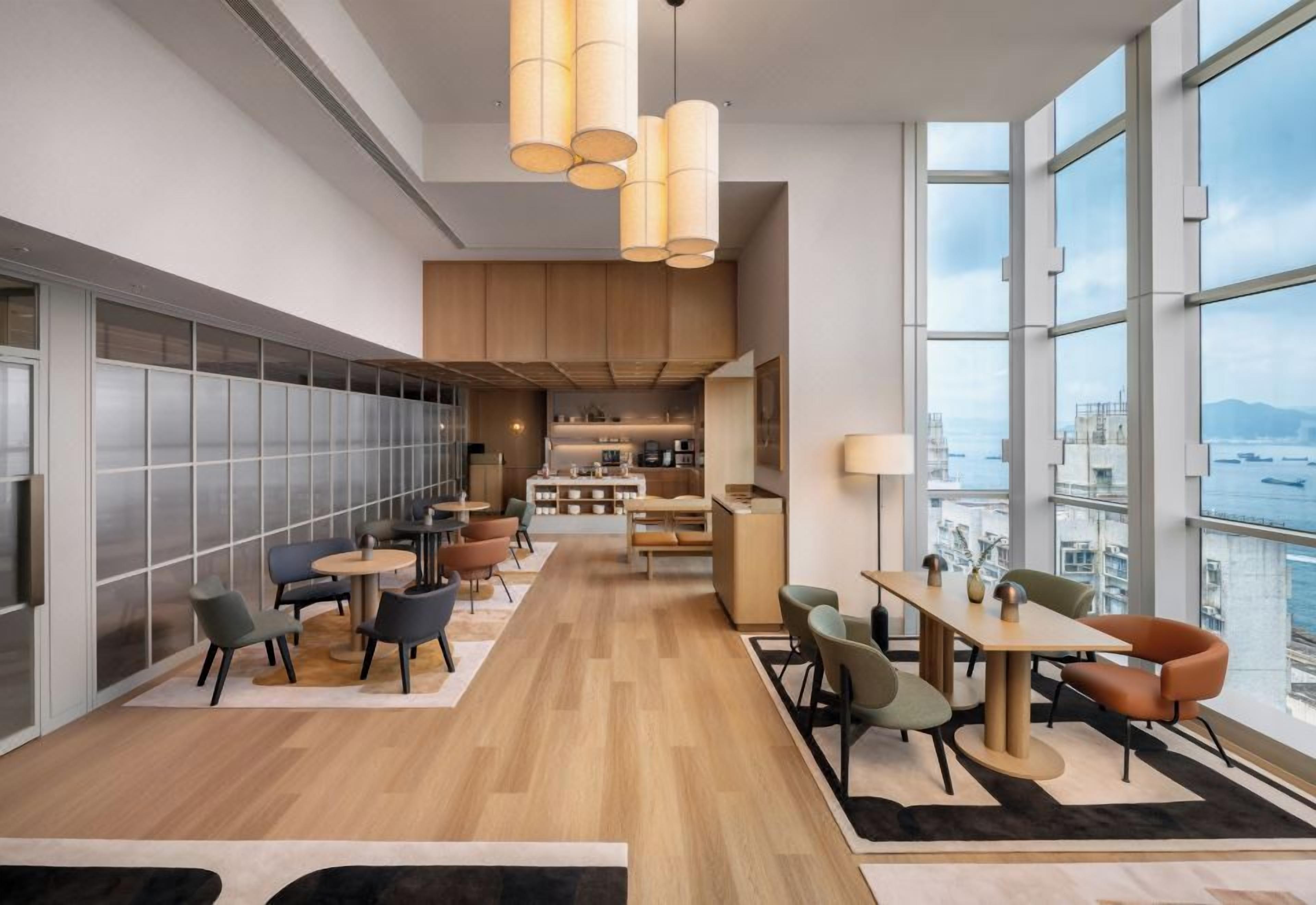 Een modern interieur met een lange gang die leidt naar een eetgedeelte, een keuken, en grote ramen met uitzicht op de stad.