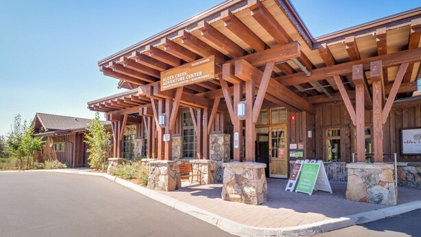 Un bâtiment en bois sur lequel est apposée une enseigne indiquant : « Alder Creek Adventure Center ».