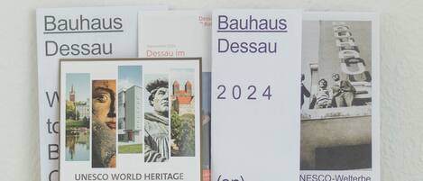 Tres folletos titulados 'Bauhaus Dessau' con el año 2024, sobre una superficie de madera.