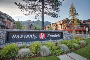 Ein Hotelschild mit 'Heavenly H Gondola' und eine Steinmauer mit Pflanzen.