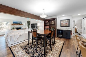 Una sala de estar moderna con comedor, chimenea y cocina.