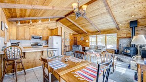 Ein Holzblockhaus-Interieur mit Küche, Essbereich und Kamin.