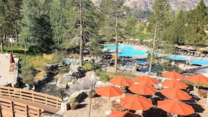 Ein Resort mit Schwimmbad, Außenbereich und einer Holzbrücke.