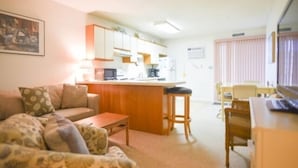 A compact living space with a kitchenette, a dining area, and a sofa. - Ocean Block, 1 Bedroom Condo, WiFi, Washer/Dryer, 2 Blocks to Seacrets (Ocean City)