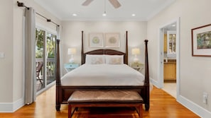 A spacious bedroom with a four-poster bed, a bench at the foot of the bed, and a view of the outdoors through a sliding glass door. - **THE ELEGANT EGRET @ OLD TOWN** Home & Pool + Last Key White Glove Service... (Key West)