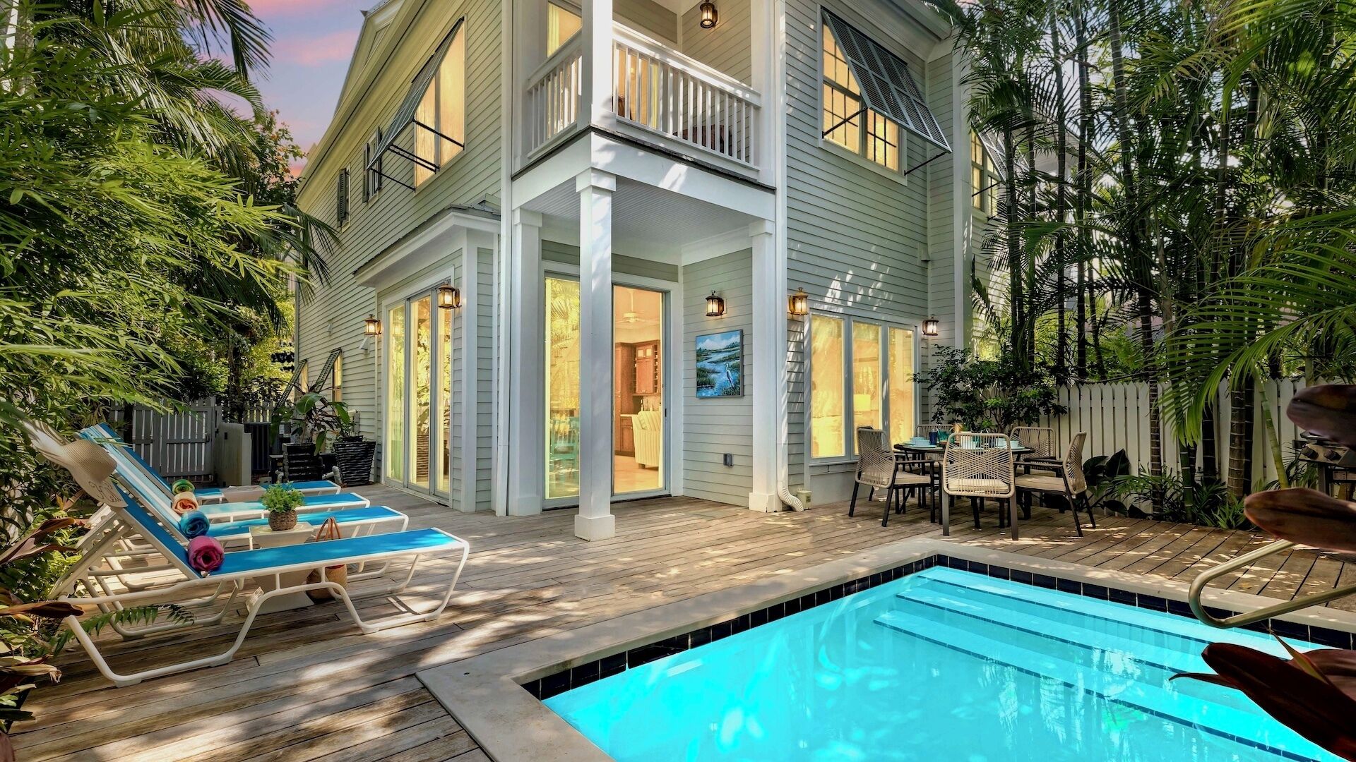 A two-story house with a swimming pool, outdoor seating, and a covered patio area.