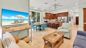 A modern living room with a TV, dining area, kitchen, and a balcony with a view of the beach. - **THE ELEGANT EGRET @ OLD TOWN** Home & Pool + Last Key White Glove Service... (Key West)