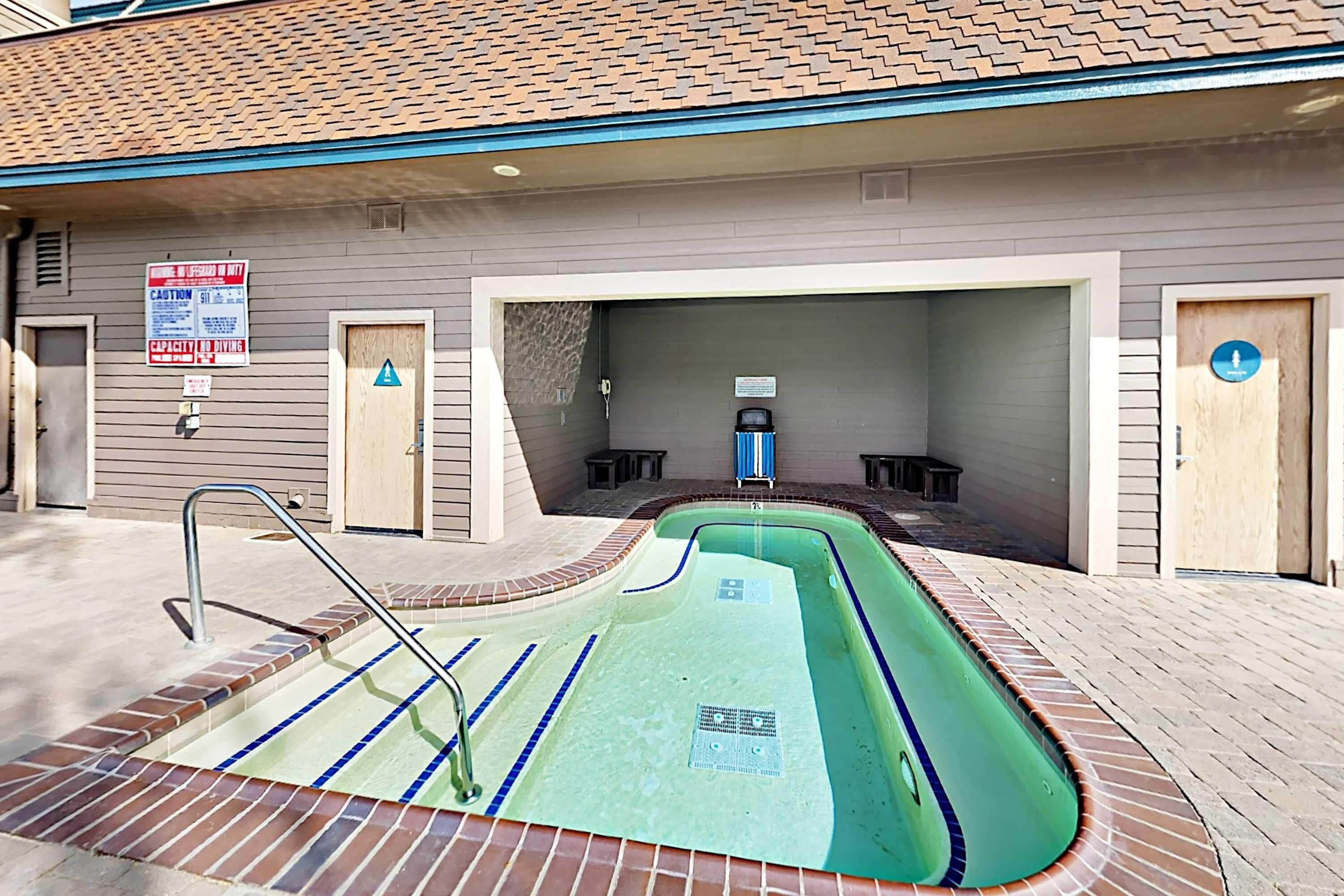 A swimming pool with a diving board, a lifeguard chair, and a sign indicating a diving area.