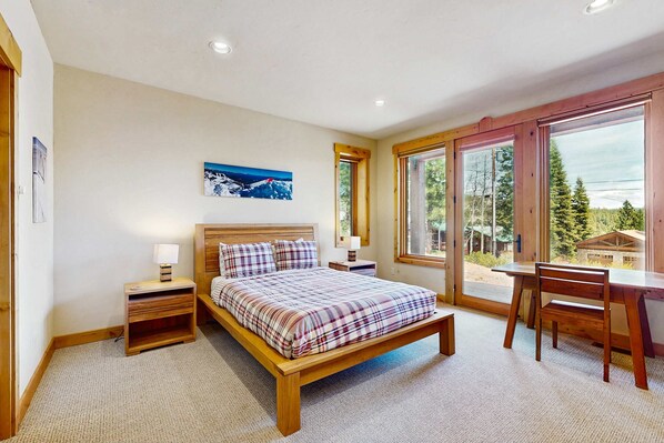 Ein Schlafzimmer mit Bett, Nachttischen, Schreibtisch und Stuhl.
