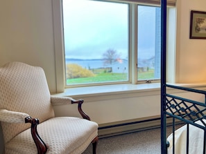 A room with a window, a chair, and a crib. - Morning Mist: 3  BR, 2.5  BA House in Harpswell, Sleeps 6 (Harpswell)