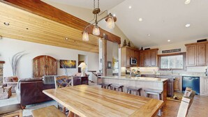 Una cocina amplia con armarios de madera, una isla grande y una zona de comedor con bancos.