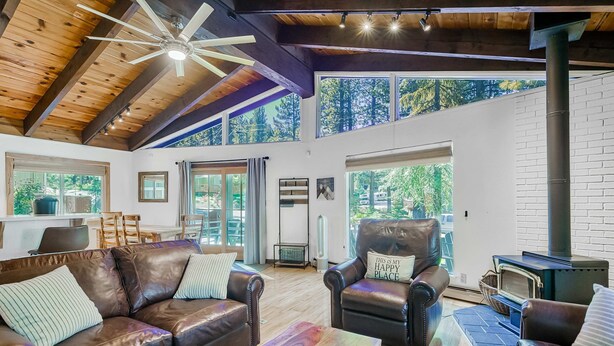 A spacious living room with leather sofas, a coffee table, and a fireplace. - Family Home with Fast WiFi, Wood Stove, Firepit, & Enclosed Yard - Dogs OK (South Lake Tahoe)