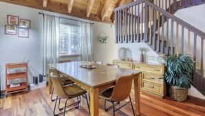 A wooden dining table with chairs, a staircase, and a large plant. - All-season, dog-friendly cabin with fireplace & deck - near Heavenly & beach (South Lake Tahoe)