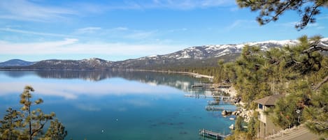 Un lago con aguas cristalinas, un muelle y un edificio con techo inclinado.
