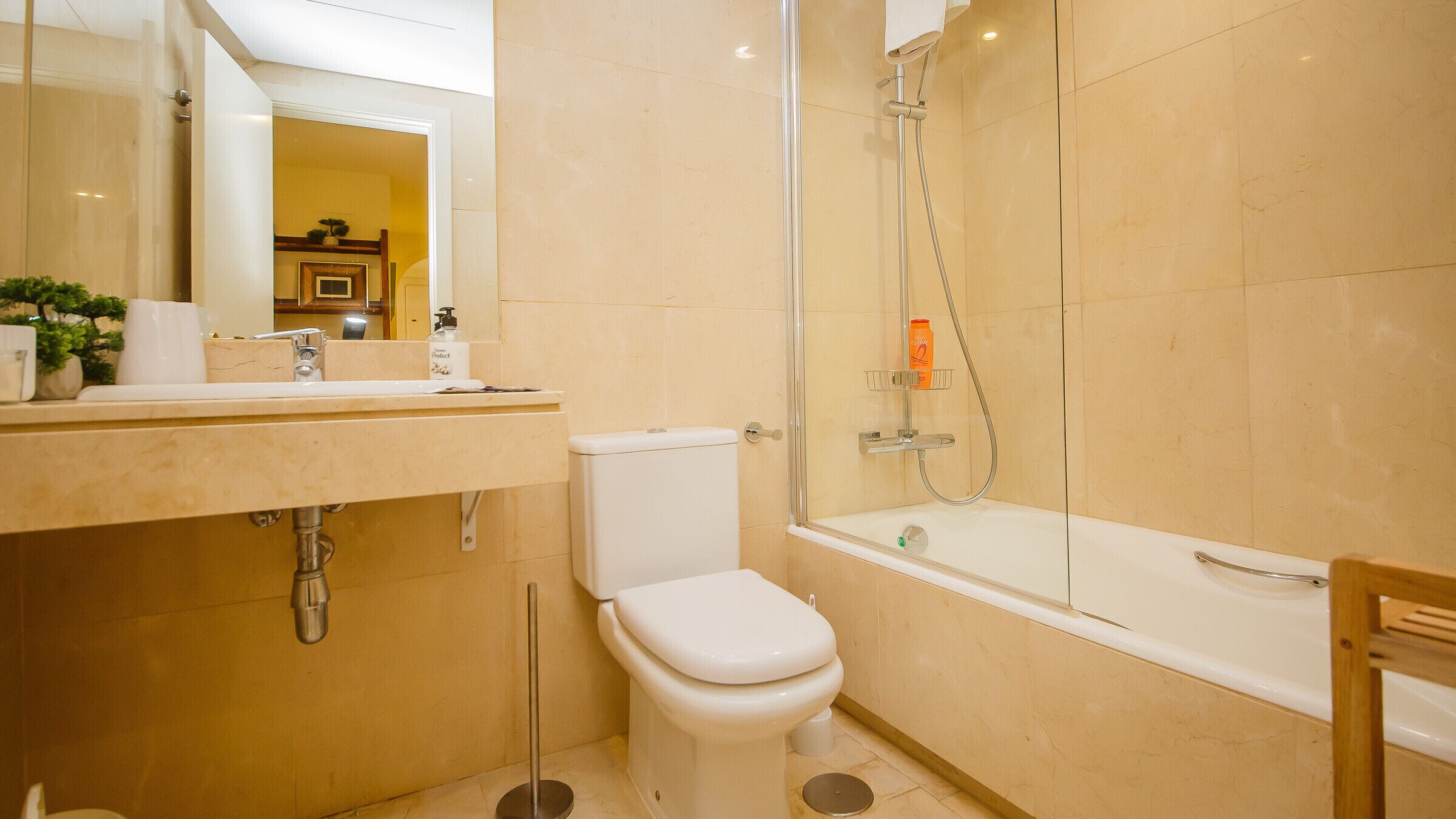 A bathroom with a toilet, sink, and shower.
