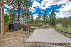 A wooden deck with a hammock, a barbecue grill, and outdoor furniture. - Home with amazing views, outdoor dining, fireplaces, pool- dogs ok (Truckee)