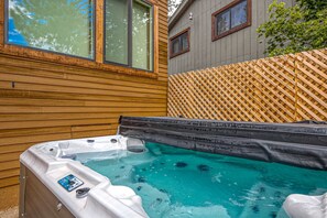 A hot tub with a control panel, wooden deck, and a wooden fence. - Home with amazing views, outdoor dining, fireplaces, pool- dogs ok (Truckee)