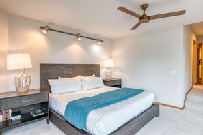 A bedroom with a bed, two bedside tables, a nightstand, a ceiling fan, and wall-mounted lighting. - Home with amazing views, outdoor dining, fireplaces, pool- dogs ok (Truckee)