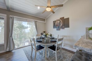 A dining area with a round table, chairs, and a ceiling fan. - Stylish home near the lake and slopes with WiFi, furnished deck & fireplace (Incline Village)