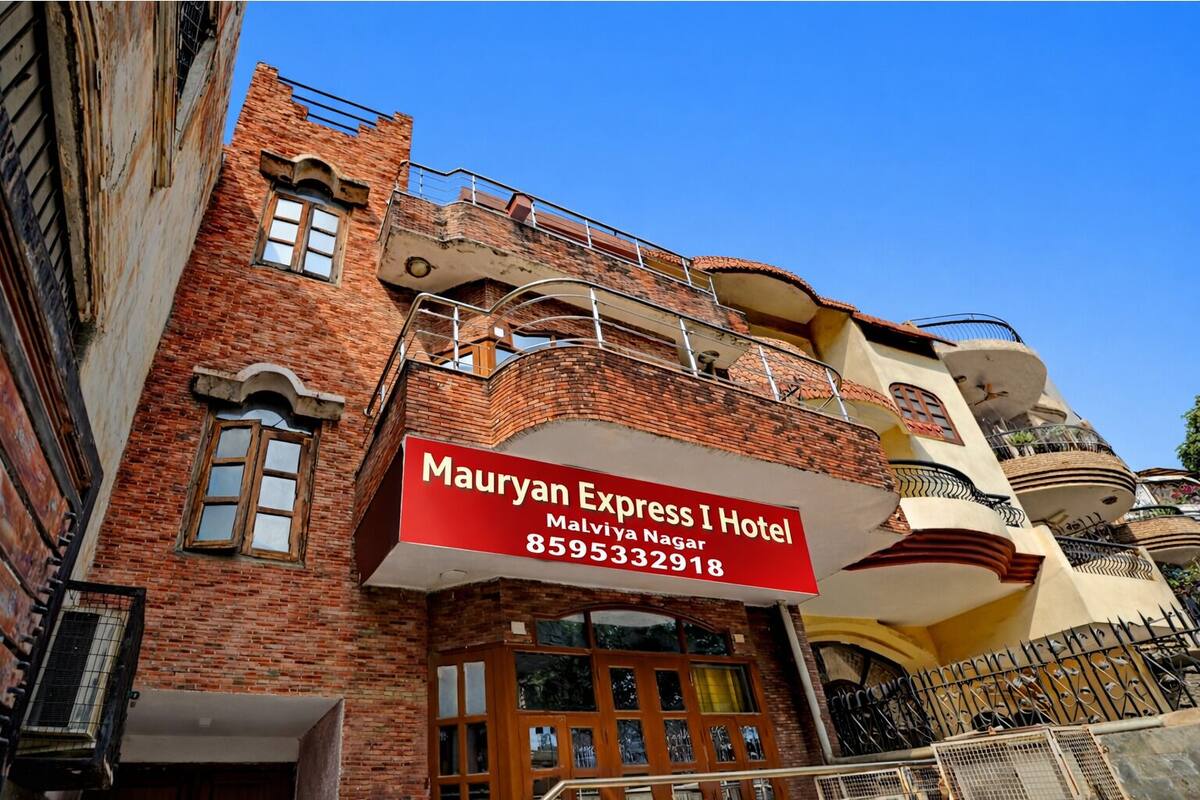 Un hotel con un letrero rojo llamativo, fachada de ladrillo y varios balcones.