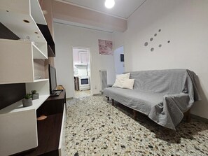 A modern living room with a sofa, a TV, and a kitchen in the background. - Come Stay Apartment - Athens Town (Athens)