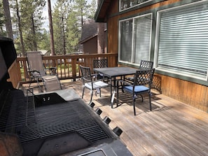 An outdoor deck with a grill, dining table, and chairs. - Spacious home with enclosed yard, private deck, fireplace, & washer&dryer (South Lake Tahoe)