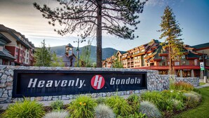 Une enseigne d’hôtel sur laquelle est inscrit « Heavenly Gondola », entourée d’un jardin aménagé avec différentes plantes et un mur de pierre.