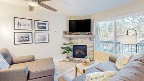 A living room with a fireplace, ceiling fan, and framed pictures on the wall. - Tranquil condo in Stateline, sleeps 4 (Stateline)