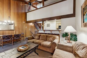 A cozy living room with a sofa, chairs, a coffee table, and a lamp. - Cozy up with a book or swim in the lakefront pool just minutes from Heavenly (South Lake Tahoe)