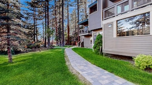 A modern two-story building with a paved pathway leading to the entrance. - Lakeside living with wonderful amenities & activities (South Lake Tahoe)