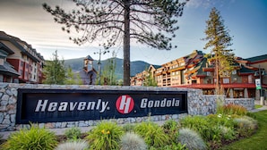 A hotel sign with 'Heavenly Gondola' written on it, surrounded by a landscaped garden with various plants and a stone wall. - Lakeside living with wonderful amenities & activities (South Lake Tahoe)