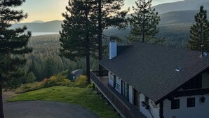 A house with a balcony, surrounded by trees and a view of a lake and mountains. - Spacious home with incredible views, full kitchen, shared  pool & tennis courts (Incline Village)