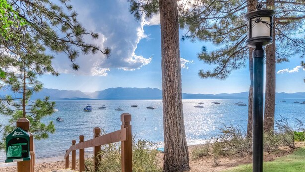 Vista costera amb una escala de fusta que condueix a una platja, un fanal i una bústia amb el nom 'Fido House'.