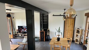 A modern living room with a dining area, a fireplace, and a television. - Villa "Quiet House near Dinan" with Private Terrace, Garden, and Wi-Fi (Aucaleuc)