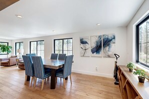 A spacious room with a dining table, chairs, and artwork on the walls. - Lakeside Modern: Water-View Dining Room & Deck, 2,600 Sq Ft, Walk to Beaches (Carnelian Bay)