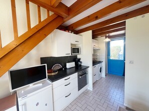 A compact kitchen with white cabinets, a microwave, a toaster, and a washing machine. - AU LARGE - Holiday home for rent Morbihan South - T203 (Saint-Philibert)